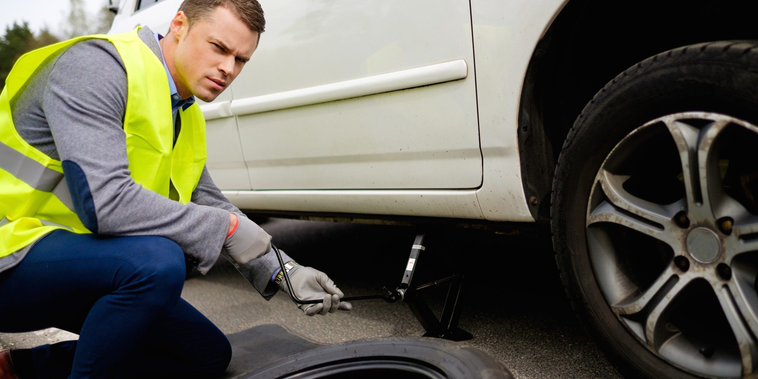 Man Changing Wheel On A Roadside